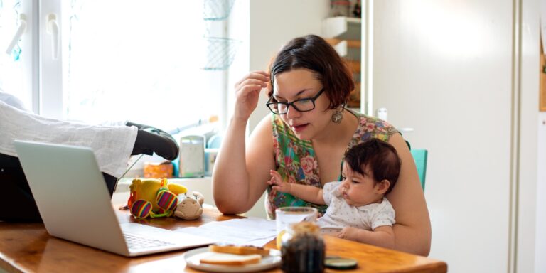 woman holding a baby working from home