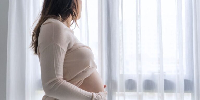 pregnant woman looking out window