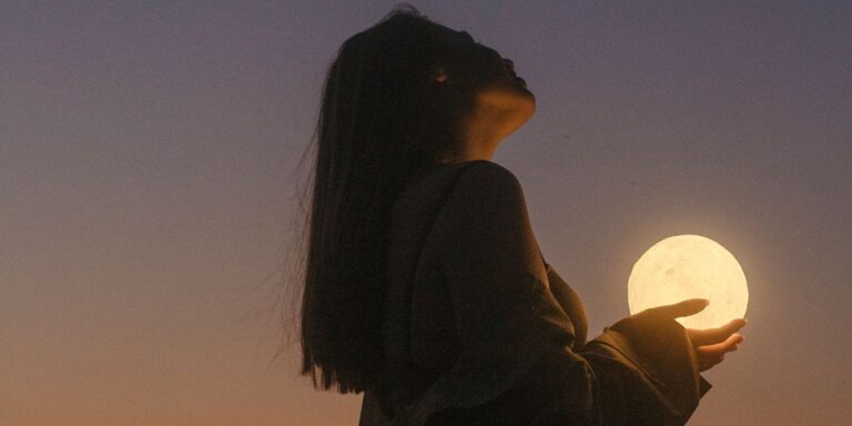 woman holding moon howling at the moon