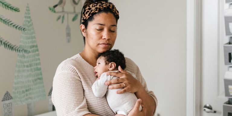 mom holding her newborn baby in a nursery